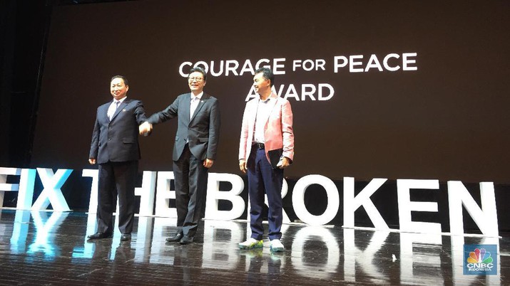'평화를 위한 용기(Courage for Peace)'상 시상식에서 남북한 대사가 단상에 올라 함께 손 잡고 있다. 