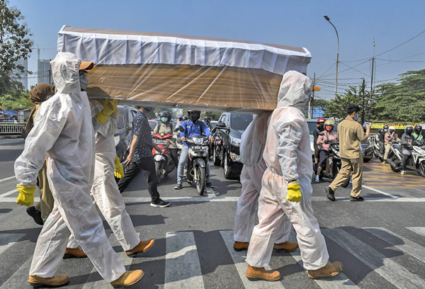 지난 8월31일 자카르타에서 경찰관들이 관을 들고 코로나19 차단 캠페인을 하고 있다.