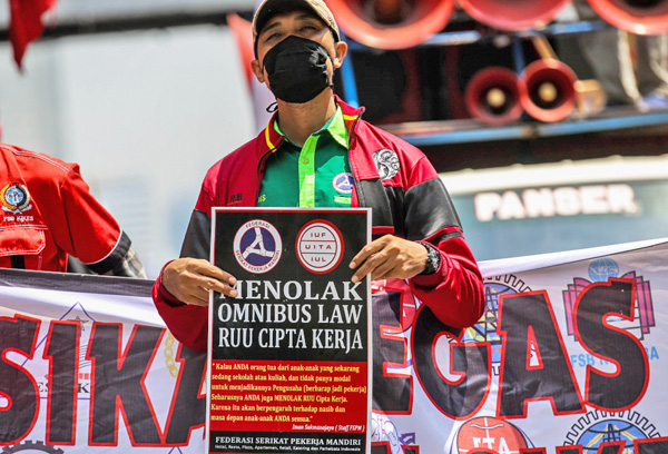Massa dari Konfederasi Serikat Buruh Seluruh Indonesia (KSBSI) menggelar aksi unjuk rasa menolak pengesahan omnibus law Undang-Undang Cipta Kerja di jalan Medan Merdeka Barat tepatnya depan Gedung Sapta Pesona mengarah ke Istana Negara, Jakarta Pusat, Senin (12/10/2020). Mereka menuntut pengesahan UU Cipta Kerja itu yang tidak mengakomodir usulan dari mitra perusahaan, Undang-undang Cipta Kerja klaster Ketenagakerjaan sangat mendegradasi hak-hak dasar buruh serta mendesak soal kontrak kerja tanpa batas, outsourcing diperluas tanpa batas jenis usaha, upah dan pengupahan diturunkan dan besaran pesangon diturunkan.
