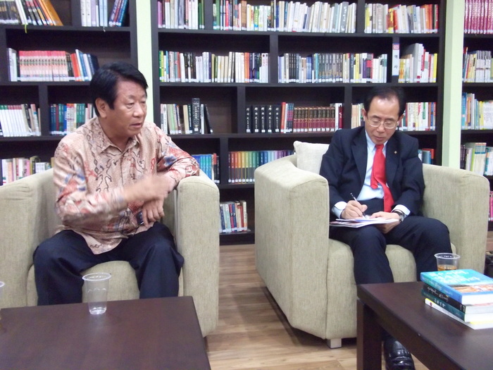 2011년 5월 당시 김성곤 수석 부의장이 신기엽 인도네시아 한인회 수석 부회장과 대화 도중 대정부 건의사항을 메모하고 있다.