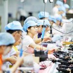 Employees work on the production line of a robot vacuum cleaner at a factory of Matsutek in Shenzhen