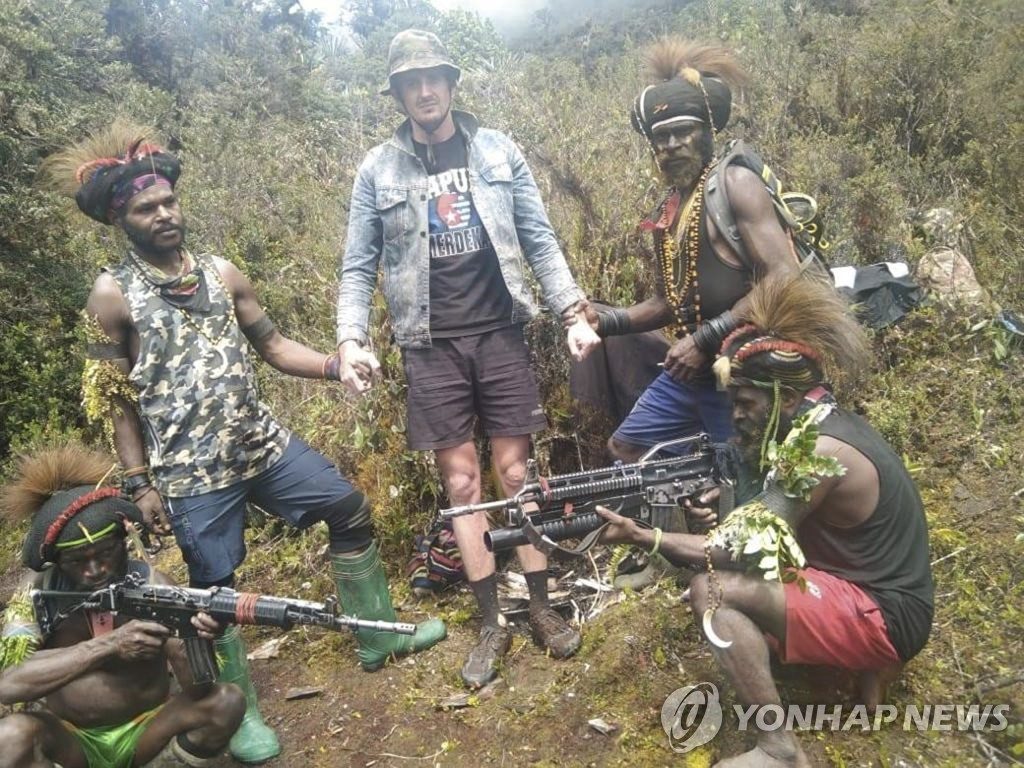 인도네시아 파푸아 반군에 납치된 뉴질랜드 출신 조종사 필립 메르텐스(가운데)가 무장한 반군들에 둘러싸여 있다. 서파푸아 민족해방군(TPNPB)은 14일(현지시간) 이 사진을 공개했지만 언제 촬영했는지는 밝히지 않았다. 2023.2.15